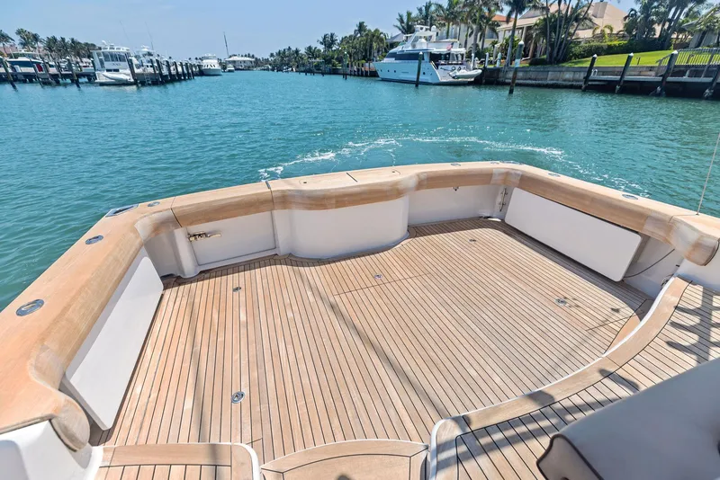 Slide: The Image of 2016 Hatteras Express Sportfish boat deck with wooden finish, docked in a marina. - 29