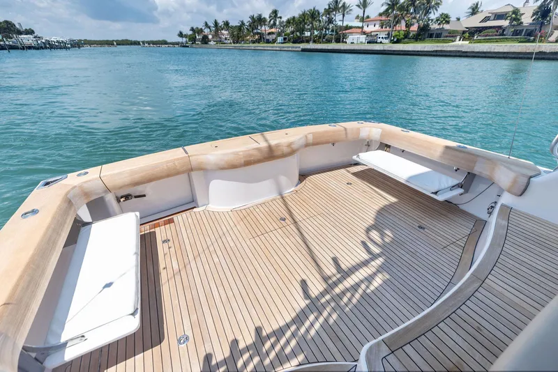 Slide: The Image of 2016 Hatteras Express Sportfish boat deck with wooden flooring, overlooking serene waters. - 32