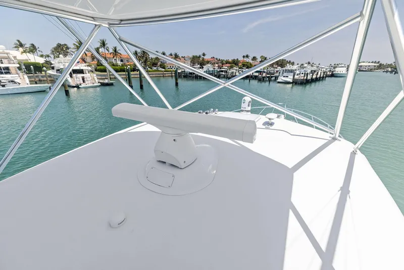 Slide: The Image of 2016 Hatteras Express Sportfish yacht with marina view, featuring sleek design and clear blue waters. - 43