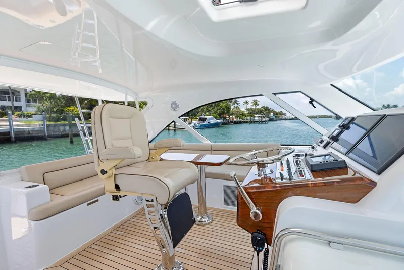 Slide: The Image of 2016 Hatteras Express Sportfish yacht interior with helm, luxurious seating, and ocean view. - 47