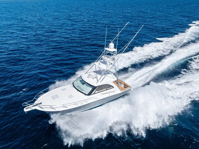 Slide: The Image of 2016 Hatteras Express Sportfish yacht cruising on open ocean under clear blue sky. - 5