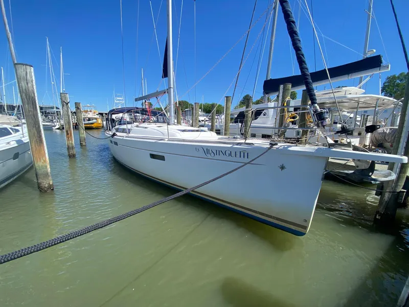 Slide: The Image of 2016 Jeanneau Sun Odyssey 479 sailboat docked in a marina under clear blue skies. - 0
