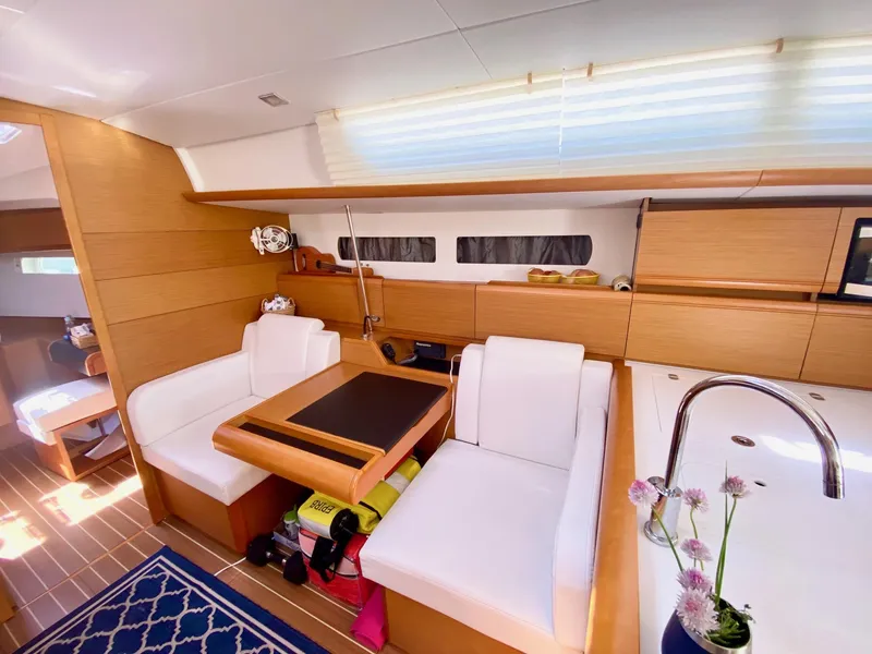 Slide: The Image of Interior of 2016 Jeanneau Sun Odyssey 479 yacht with modern seating and kitchen area. - 12