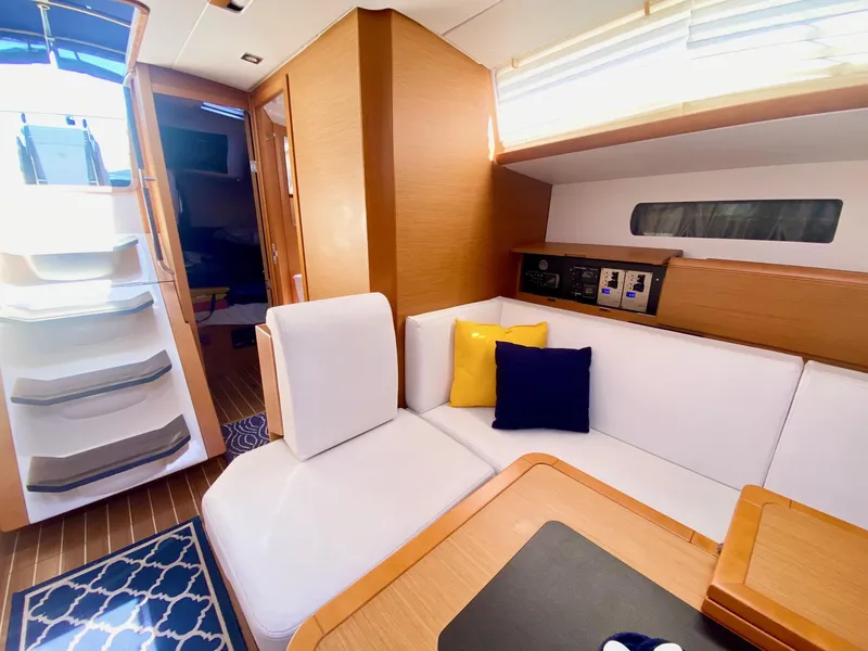 Slide: The Image of Interior of 2016 Jeanneau Sun Odyssey 479 yacht with white seating and colorful cushions. - 14