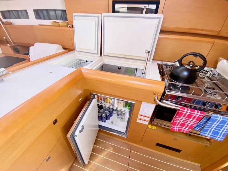 Slide: The Image of Modern kitchen in 2016 Jeanneau Sun Odyssey 479 yacht with fridge, stove, and kettle. - 18