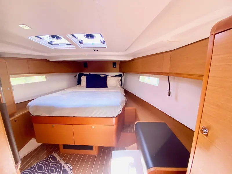 Slide: The Image of Luxurious cabin interior of 2016 Jeanneau Sun Odyssey 479 yacht with cozy bed and wooden finish. - 2