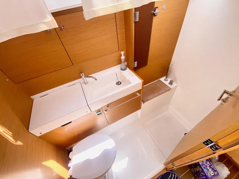 Slide: The Image of 2016 Jeanneau Sun Odyssey 479 bathroom with wooden cabinetry and modern fixtures. - 22