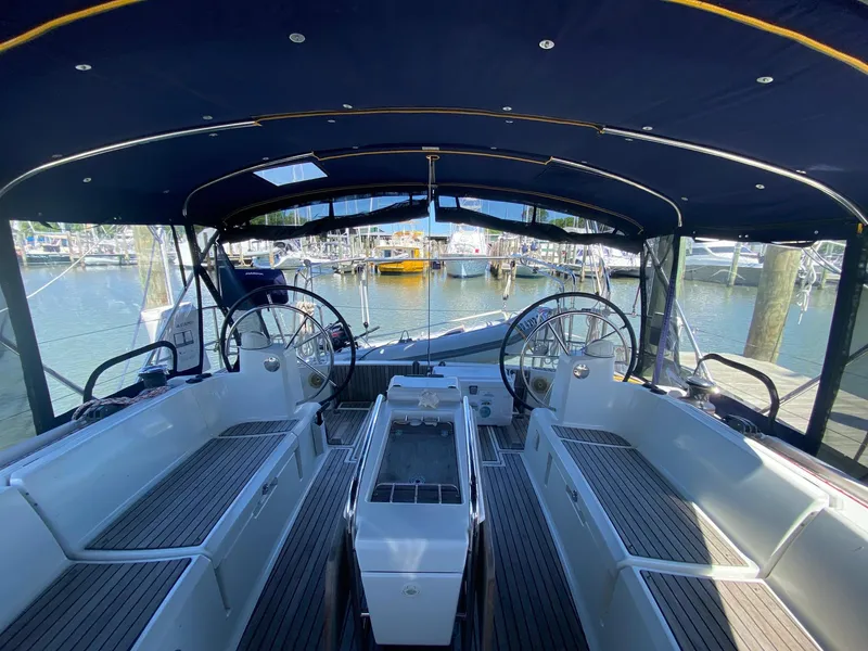 Slide: The Image of 2016 Jeanneau Sun Odyssey 479 yacht cockpit with dual steering wheels and marina view. - 27