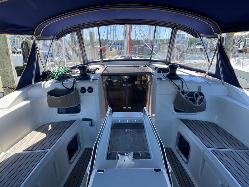 Slide: The Image of Cockpit of 2016 Jeanneau Sun Odyssey 479 sailboat with blue canopy and wooden seating. - 28
