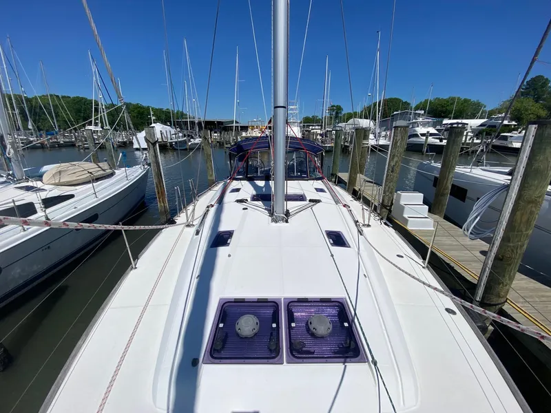 Slide: The Image of 2016 Jeanneau Sun Odyssey 479 sailboat docked at a marina under clear blue skies. - 36
