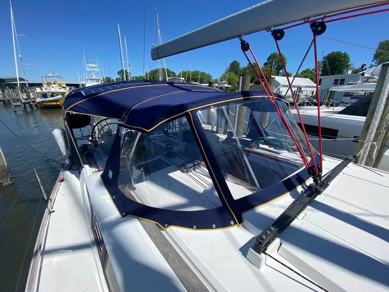 Slide: The Image of 2016 Jeanneau Sun Odyssey 479 sailboat with blue canopy docked at marina. - 38