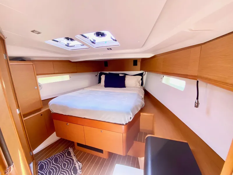 Slide: The Image of Interior cabin of 2016 Jeanneau Sun Odyssey 479 yacht, featuring a cozy bed and wooden finish. - 4