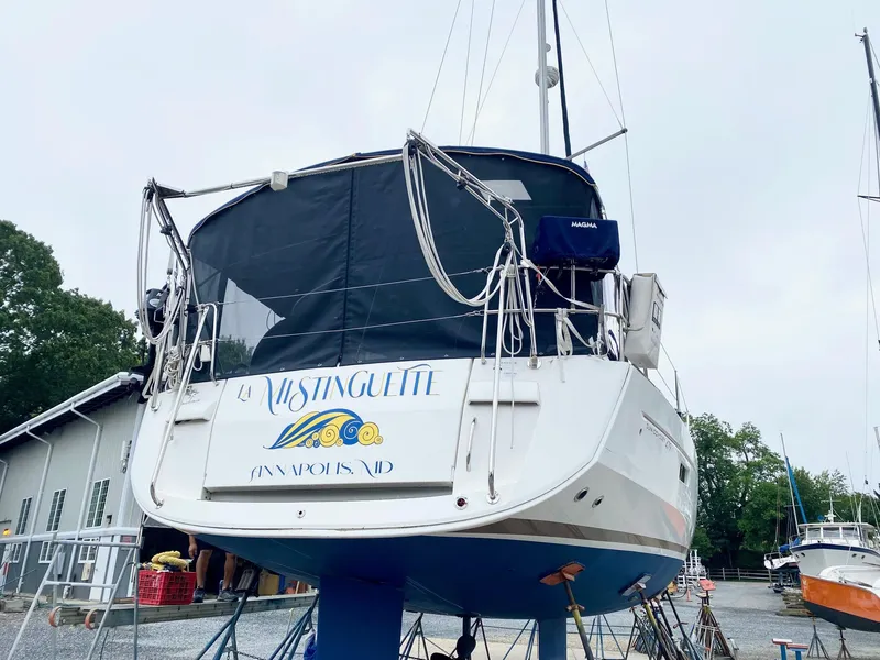 Slide: The Image of 2016 Jeanneau Sun Odyssey 479 sailboat on land, rear view with cover. - 45