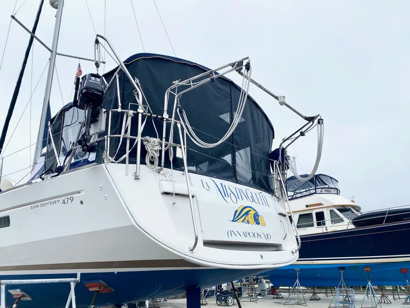 Slide: The Image of 2016 Jeanneau Sun Odyssey 479 sailboat on dry dock, rear view with cover. - 46