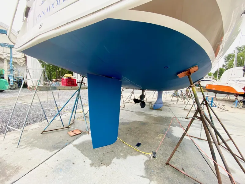 Slide: The Image of 2016 Jeanneau Sun Odyssey 479 sailboat on stands, showcasing its blue hull and keel. - 49