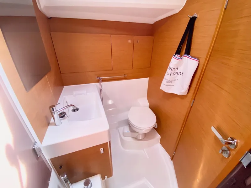 Slide: The Image of 2016 Jeanneau Sun Odyssey 479 bathroom with sink, toilet, and wooden cabinetry. - 7