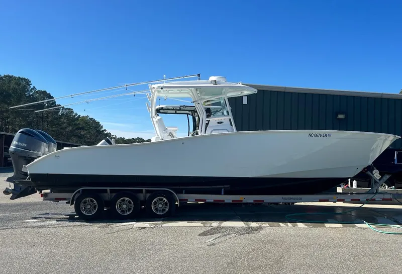 The Image of 2019 Cape Horn 31 boat on trailer, parked outdoors under clear blue sky. - 1