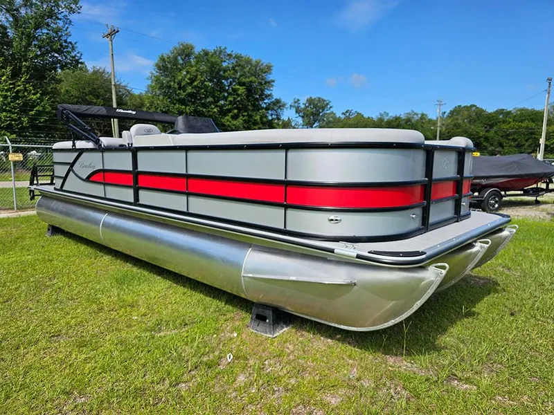 Slide: The Image of 2025 Bentley Pontoons Legacy 243 Navigator with Mercury outboard engine, covered and parked outdoors. - 2