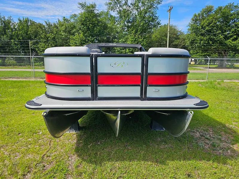 Slide: The Image of 2025 Bentley Pontoons Legacy 243 Navigator on grass, showcasing sleek design and vibrant red accents. - 4