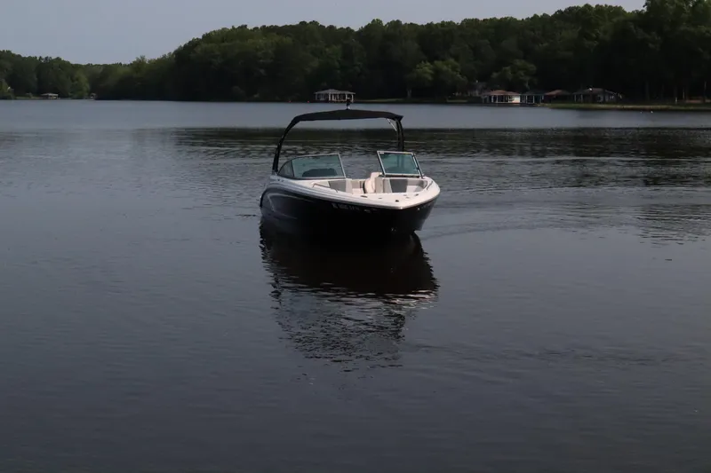 Slide: The Image of Chaparral 23 SSi 2020 boat on a calm lake with forested shoreline. - 4