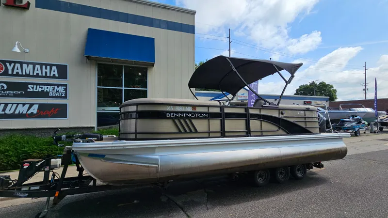 Slide: The Image of 2021 Bennington L 22 Quad Bench pontoon boat on trailer outside dealership. - 1