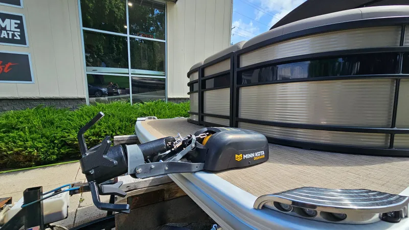 Slide: The Image of 2021 Bennington L 22 Quad Bench with Minn Kota motor, parked outside a building. - 6