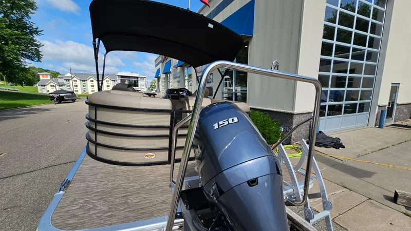 Slide: The Image of 2021 Bennington L 22 Quad Bench pontoon boat with 150 HP engine, docked near a building. - 7