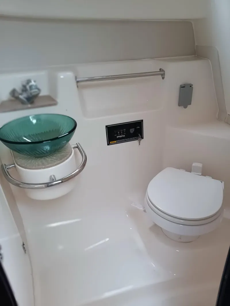Slide: The Image of 2009 Pursuit 310 OS boat bathroom with modern sink and toilet. - 14