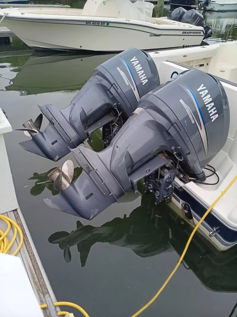 Slide: The Image of Twin Yamaha outboard motors on a 2009 Pursuit 310 OS boat, docked in a marina. - 4