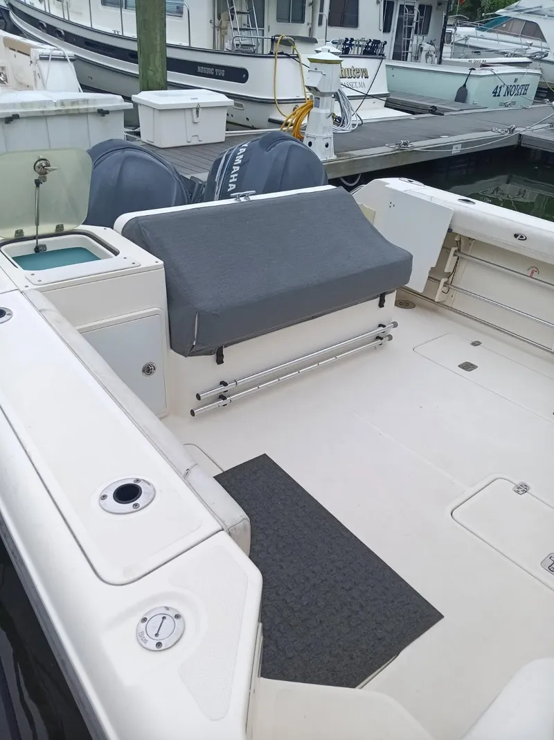 Slide: The Image of 2009 Pursuit 310 OS boat deck with covered seating and Yamaha engines at dock. - 5