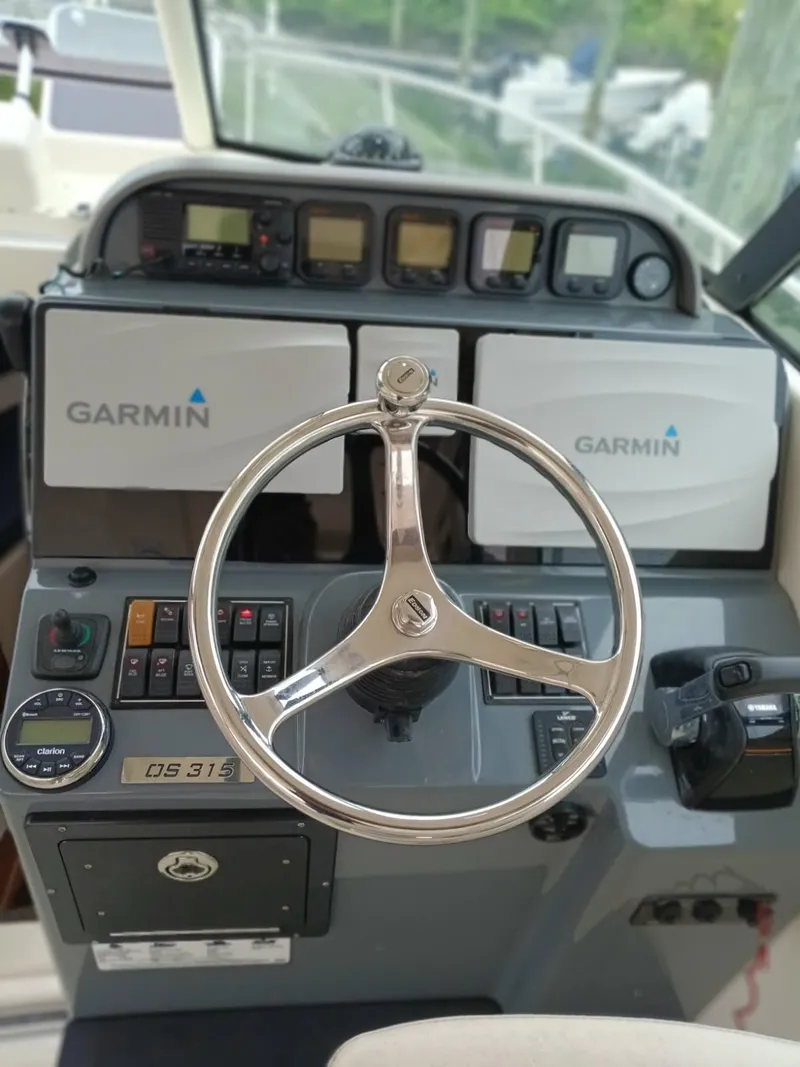 Slide: The Image of 2009 Pursuit 310 OS boat dashboard with Garmin navigation and steering wheel. - 8