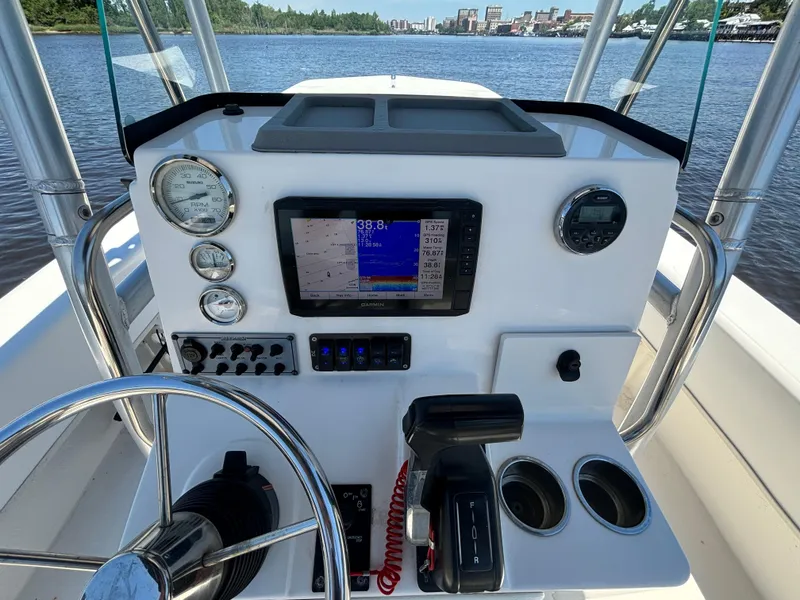 Slide: The Image of Boat dashboard with steering wheel, gauges, and navigation system on a Sundance B22CR, 2020 model. - 11