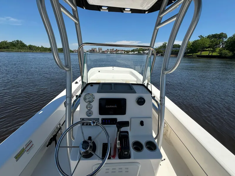 Slide: The Image of 2020 Sundance B22CR boat console with steering wheel on calm water. - 12