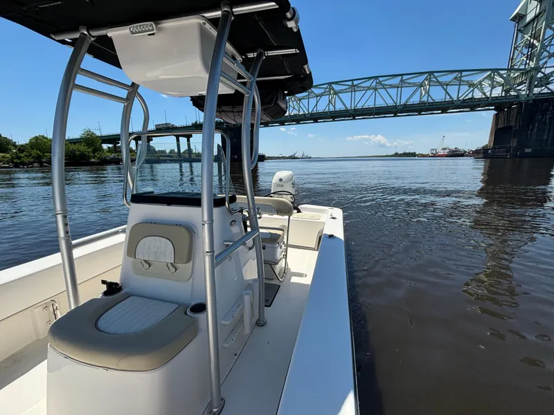 Slide: The Image of 2020 Sundance B22CR boat on a river near a bridge under a clear blue sky. - 14