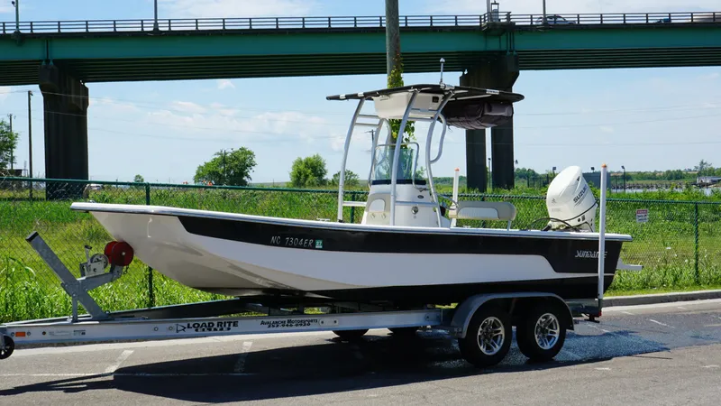 Slide: The Image of 2020 Sundance B22CR boat on trailer, parked near a bridge, sunny day. - 4