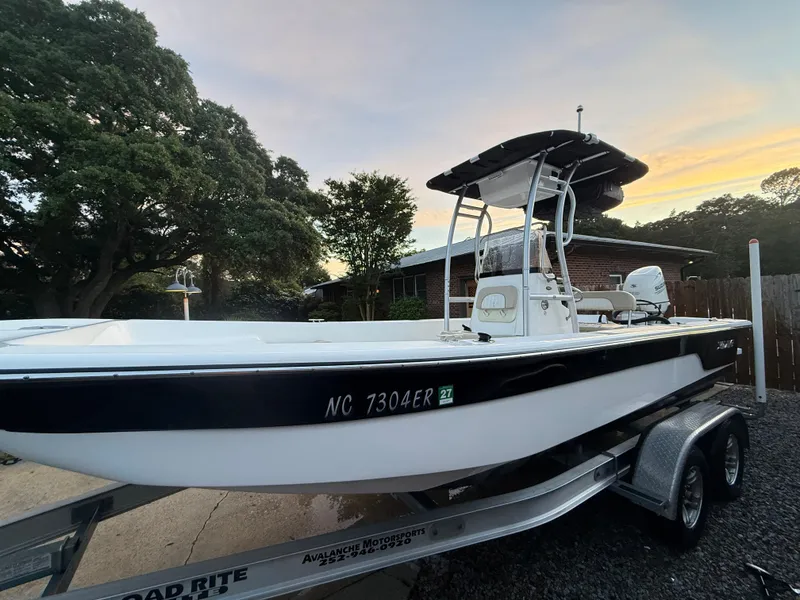 Slide: The Image of 2020 Sundance B22CR boat on trailer at sunset, surrounded by trees. - 8