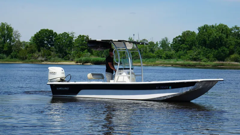 Slide: The Image of 2020 Sundance B22CR boat on a calm river with lush green trees. - 9
