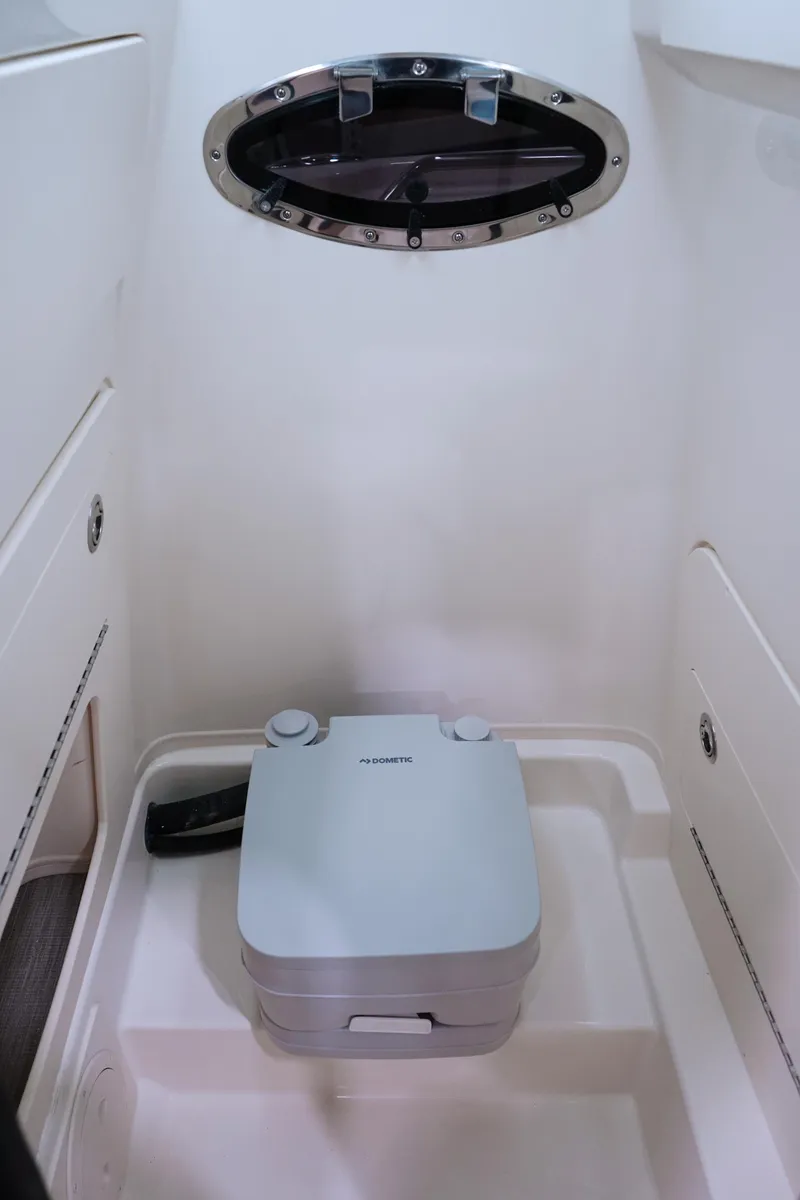 Slide: The Image of 2026 Grady-White Fisherman 216 boat interior with compact portable toilet and porthole. - 14