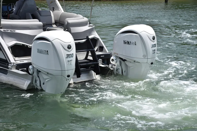 Slide: The Image of 2024 Bennington 27 QFB with dual Yamaha 300 V6 outboard engines on water. - 34
