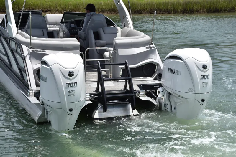 Slide: The Image of 2024 Bennington 27 QFB boat with dual Yamaha 300 V6 outboard engines on water. - 35