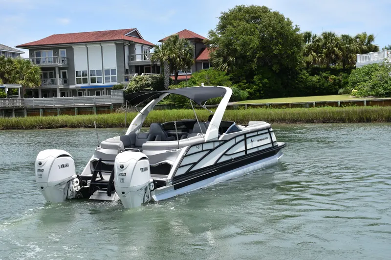 Slide: The Image of 2024 Bennington 27 QFB pontoon boat with Yamaha engines on a scenic waterway. - 37