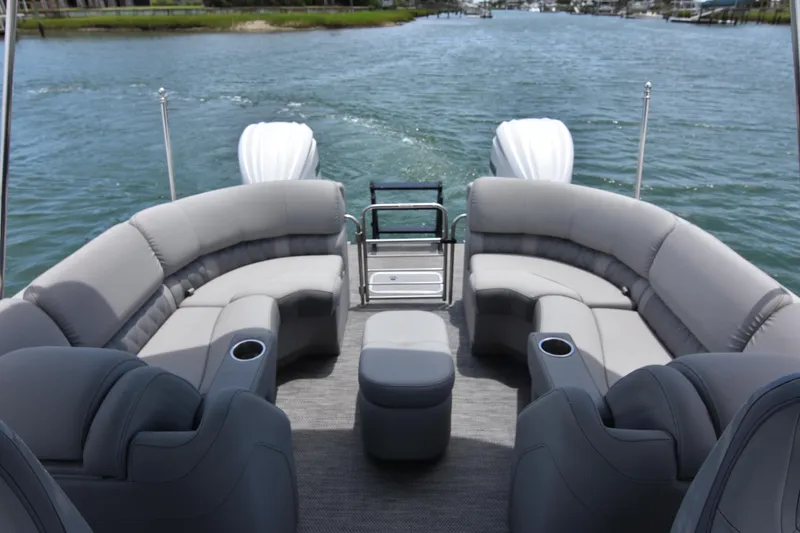 Slide: The Image of 2024 Bennington 27 QFB pontoon boat with luxurious seating on a serene waterway. - 38