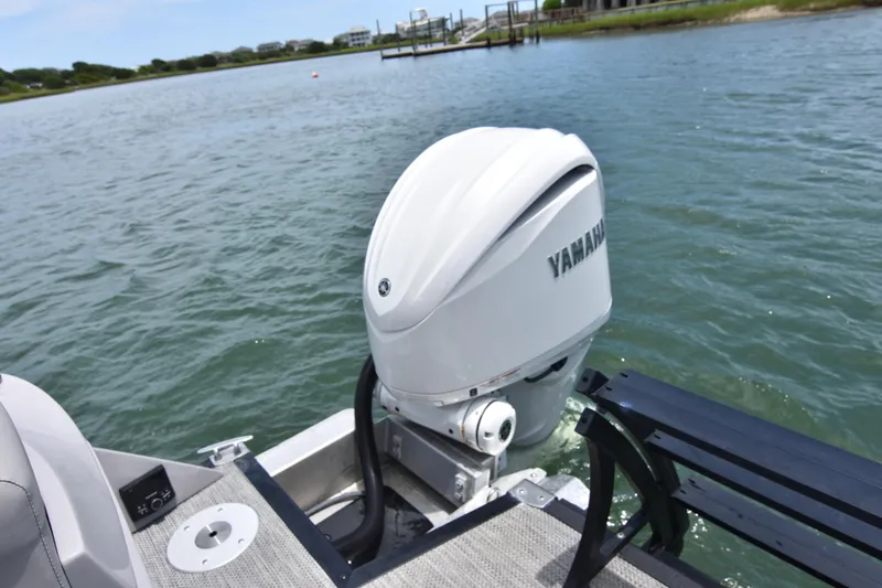 Slide: The Image of 2024 Bennington 27 QFB with Yamaha outboard motor on a serene lake. - 42