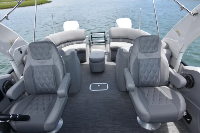Slide: The Image of 2024 Bennington 27 QFB boat interior with luxurious gray seating and water view. - 43
