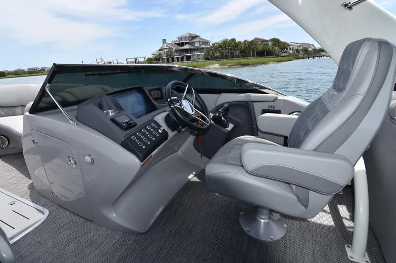 Slide: The Image of 2024 Bennington 27 QFB boat interior with modern helm and luxurious captain's chair. - 46