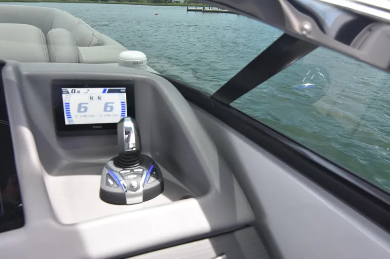 Slide: The Image of 2024 Bennington 27 QFB boat dashboard with control panel and water view. - 49