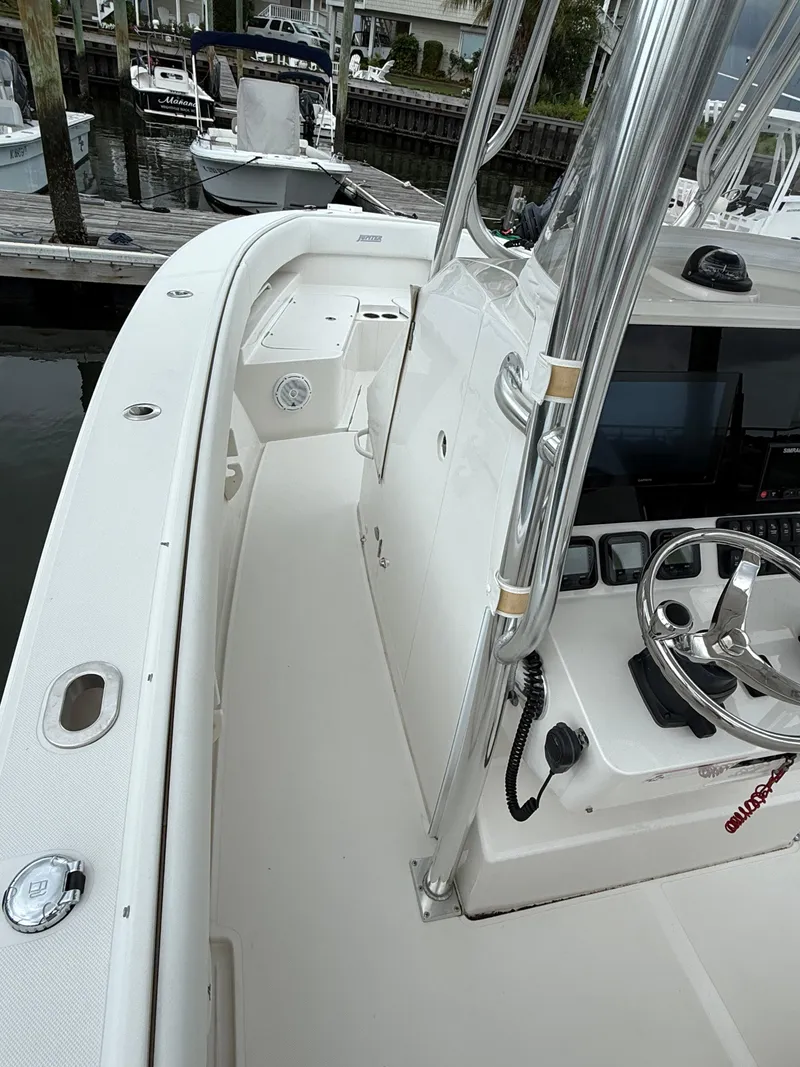 Slide: The Image of 2012 Jupiter 26 boat interior with steering wheel and console, docked at marina. - 10
