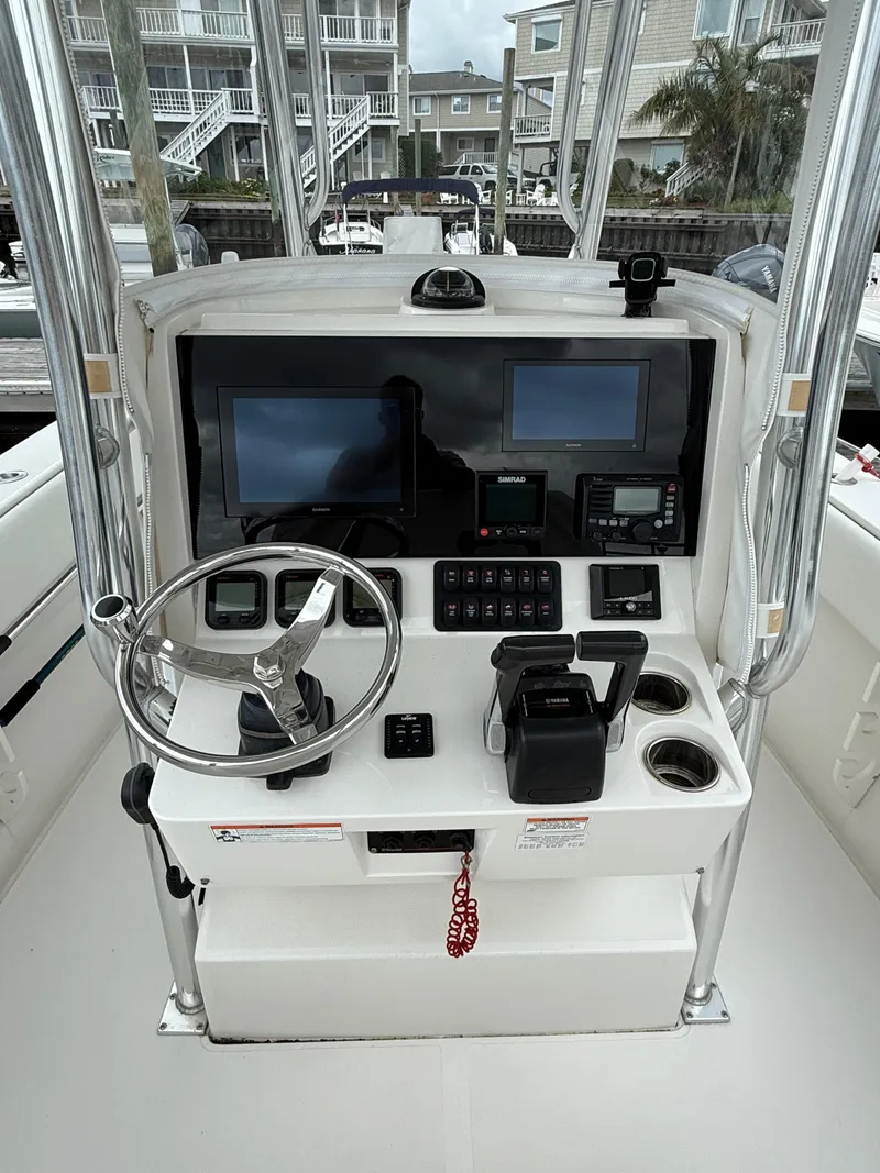 Slide: The Image of Helm of 2012 Jupiter 26 boat with steering wheel and navigation screens. - 11