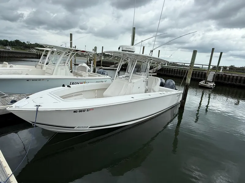 Slide: The Image of 2012 Jupiter 26 boat docked in a marina under cloudy skies. - 12