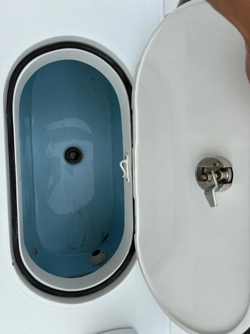 Slide: The Image of Open livewell compartment on a 2012 Jupiter 26 boat, showing interior and latch. - 15